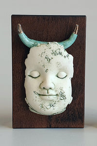 Block head doll face with platinum and green horns