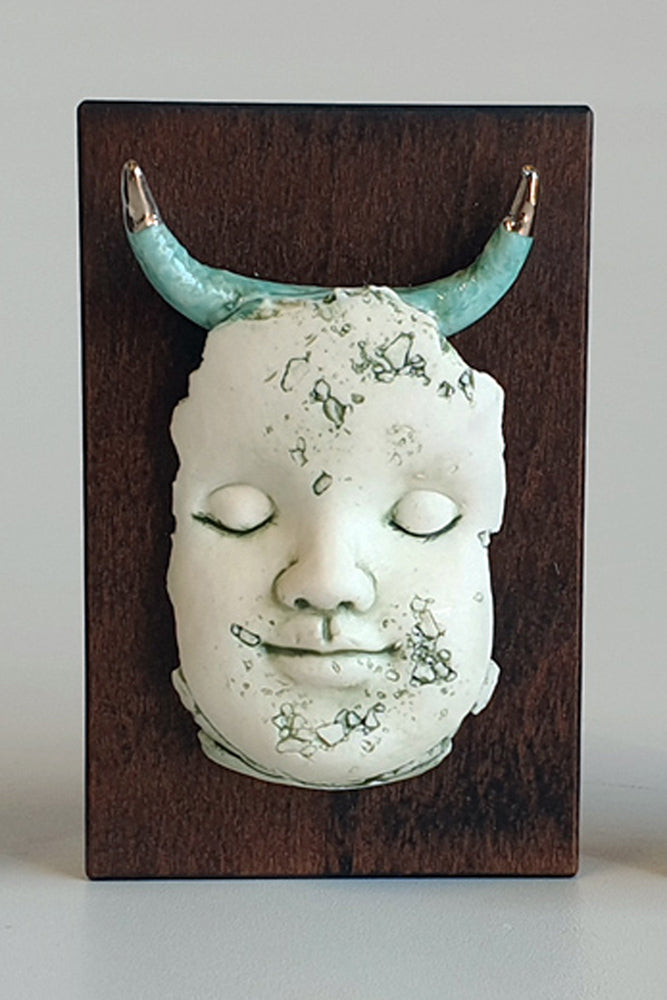 Block head doll face with platinum and green horns