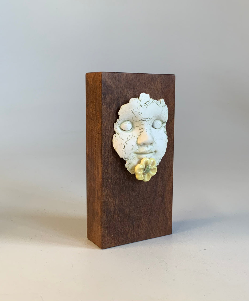 Block head doll face with yellow flower